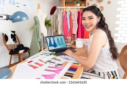 Beautiful asian Fashion designer drawing sketches for new collection on computer laptop. Designer creative workshop studio. - Powered by Shutterstock