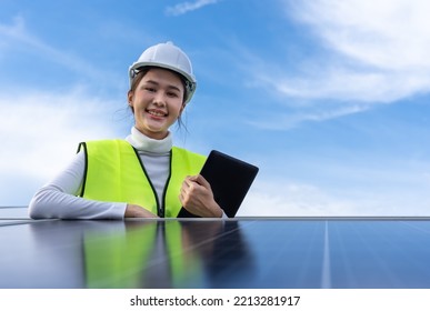 Beautiful Asian Female Engineer Uses A Black Tablet To Inspect Solar Power Station, Clean Energy.