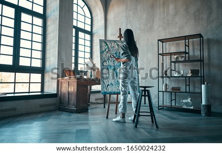 Beautiful asian female painter in art studio. Young talanted artist working.