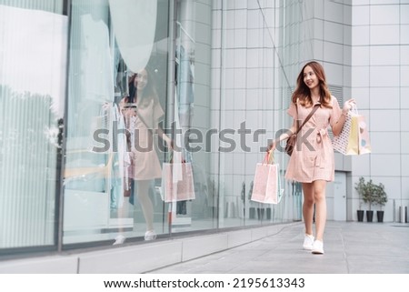 Beautiful asian female woman girl holding shopping bags, Walk enjoy smiling while doing shopping outside of department store malls window outdoors fashion lifestyle