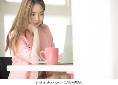 Beautiful Asian Female Working With Laptop Computer With Coffee Cup On The Desk 