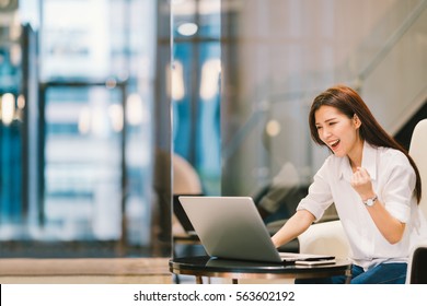 Beautiful Asian Girl Celebrate With Laptop, Success Happy Pose. E-commerce, University Education, Internet Technology, Or Startup Small Business Concept. Modern Office Or Living Room With Copy Space