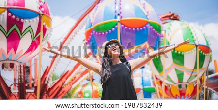 a beautiful asian girl enjoy her holiday at amusement park on a sunny day, nice clear sky, women wearing sunglasses, smiling girl, happy vacation