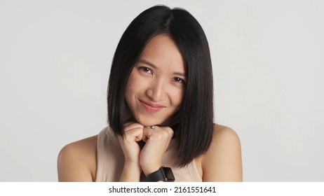 Beautiful Asian Girl Looking Cute At Camera Isolated On White Background. Pretty Female Smiling As Hearing Compliment From Stranger