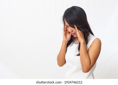 Beautiful asian girl standing while holding her head. headache concept. Isolated on white background with copyspace