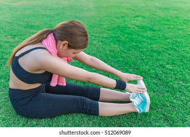 Beautiful asian girl Stretch seating on the lawn in the soccer field,excercise,warm body - Powered by Shutterstock