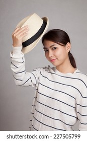 Beautiful Asian Girl Take Off A  Hat On Gray Background