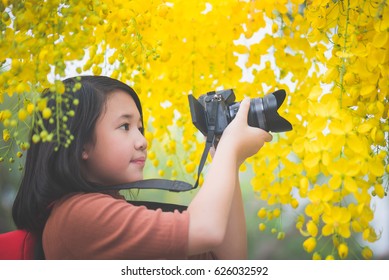 Beautiful Asian Girl Take Photo With Blooming Yellow Flower,Thailand Travel Concept