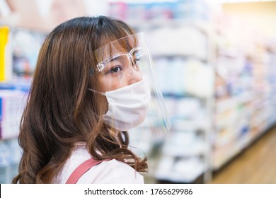 beautiful asian girl wearing facemask face shield protection coronavirus covid-19, shopping trolley buying food water grocery shopping at super store market supply for world pandemic home quarantine