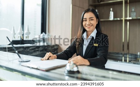Beautiful asian hotel receptionist in  uniforms at desk in lobby Friendly and welcome staff in hotel reception counter