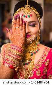 Beautiful Asian Indian Bride Wearing Ethnic Traditional Outfit And Heavy Gold Jewellery Bangles Henna Design Hand Smiling Posing Wedding Day