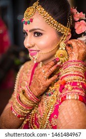 Beautiful Asian Indian Bride Wearing Ethnic Traditional Outfit And Heavy Gold Jewellery Earring Smiling Posing Wedding Day