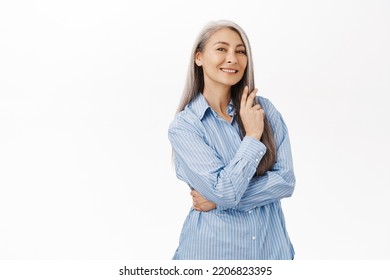 Beautiful Asian Lady, Senior Woman With Grey Hair, Good Facial Skin, Smiling And Looking Happy At Camera, Standing Over White Background.