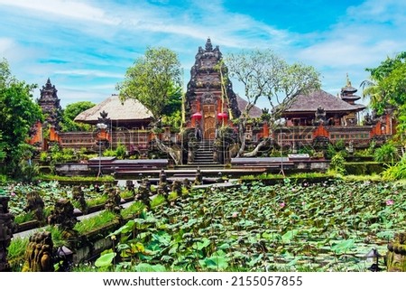 Beautiful asian landscape, lotus flower pond water garden,  ancient red hindu temple, blue sky - Ubud, Pura Taman Saraswati (Water Palace), Bali, Indonesia 