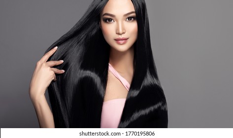 Beautiful asian model girl with shiny black and straight long hair . Keratin straightening . Treatment, care and spa procedures for haired . Chinese girl with smooth hairstyle