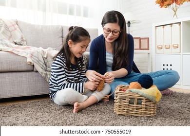 Beautiful Asian Mom Teaches Her Daughter How To Knitting For The Autumn Sweater For Cold Season Is Coming In The Living Room At Home