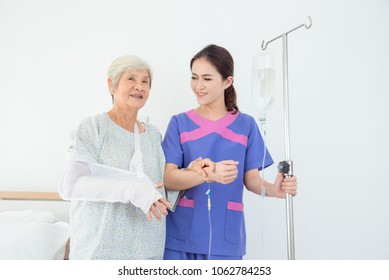 Beautiful Asian Nurse Helping Senior Patient To Walking