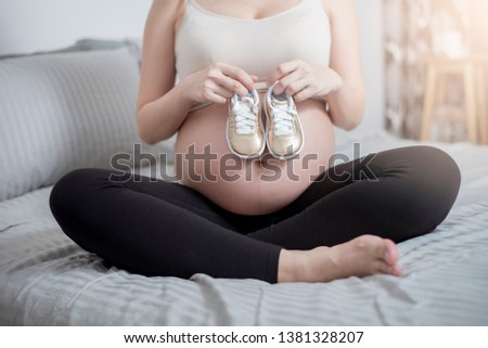 Image, Stock Photo Baby sneakers held by pregnant