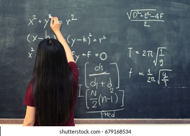 Beautiful Asian student writing on blackboard with chalk in classroom. - Powered by Shutterstock