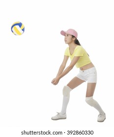 Beautiful Asian teenage girl hitting a volleyball isolated on white background