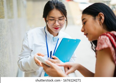 Beautiful Asian Tour Guide Woman Giving Direction To Traveler On Smartphone At The Street.