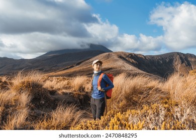 Beautiful asian traveler woman hiking and enjoying with volcanic mountain and golden meadow in Tongariro alpine crossing track on sunny day at North Island of New Zealand - Powered by Shutterstock