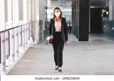 Beautiful Asian Woman In A Black Suit Wearing Medical Hygiene Protective Mask Walking On In City To Work At Office. Idea For Health Care And Prevent From Risk Of Coronavirus Epidemic Outbreak.