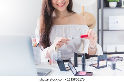 Beautiful Asian Woman Blogger Is Showing How To Make Up And Use Cosmetics. In Front Of The Laptop To Recording Vlog Video Live Streaming At Home.Business Online Influencer On Social Media Concept.