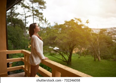 Beautiful Asian Woman Breathing Fresh Air On Villa Balcony In Morning 