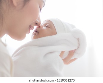 A beautiful Asian woman carried her newborn baby and kiss with happiness after having a long pregnancy and just giving birth