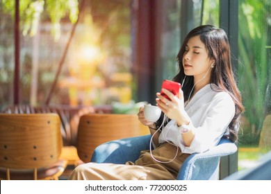 A Beautiful Asian Woman Close Her Eyes And Listening To Music With Headphone While Drinking Coffee With Feeling Happy And Relax In Cafe