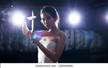 Beautiful Asian Woman Demonstrates Practice Martial Art Knife Technique Against Threat Weapon Attack, Concept Girl Self Defense Thief. Studio Lighting Rim Back Light Dark Low Exposure Silhouette