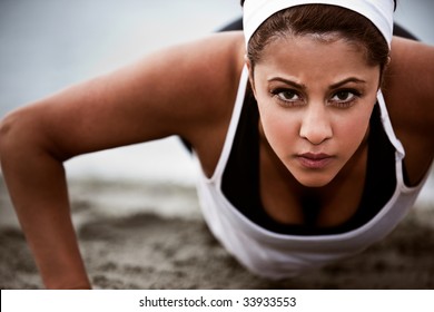 A Beautiful Asian Woman Doing Push Up At A Beach