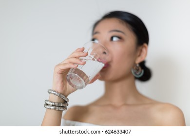 Beautiful Asian Woman Drinking A Glass Of Water.