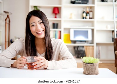 Beautiful Asian Woman Drinking A Glass Of Tea