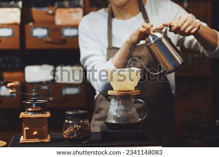 Beautiful Asian woman dripping coffee in the cafe, Younger barista dripping coffee at counter.