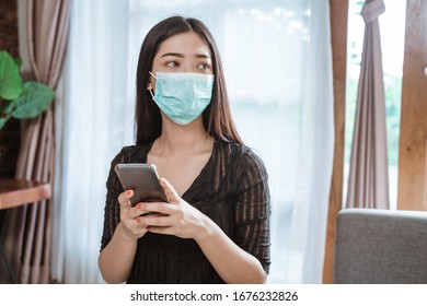 Beautiful Asian Woman During Epidemic Lockdown Stay Home Using Mobile Phone For Social Interaction