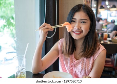 Beautiful Asian Woman Eating Sashimi, Japanese Food. 