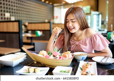 Beautiful Asian Woman Eating Sashimi, Japanese Food. 