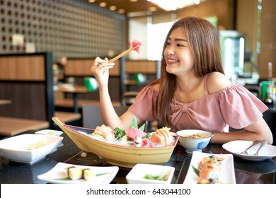 Beautiful Asian Woman Eating Sashimi, Japanese Food. 