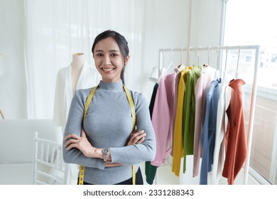 Beautiful asian woman fashion designer standing in the clothing store and studio. In front of the camera to recording vlog video live streaming.Business online influencer on social media concept. - Powered by Shutterstock