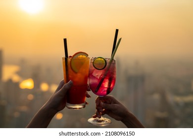 Beautiful Asian woman friends meeting and drinking cocktail together at skyscraper rooftop restaurant in metropolis at summer sunset. Female friend enjoy outdoor lifestyle activity in the city at nigh - Powered by Shutterstock