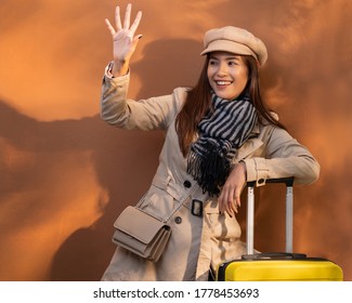 Beautiful Asian Woman Going To Travel During The Autumn. Brown Backdrop.She Posted Byebye