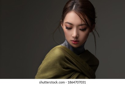 Beautiful Asian Woman In A Green Shawl. Beauty Of Mysterious Chinese Girl With Flowing Hair. Fashion, Clothing And Cosmetics