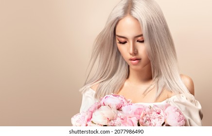 Beautiful Asian Woman  With Hair Coloring In Ultra Blond. Stylish Hairstyle Done In A Beauty Salon. Fashion, Cosmetics And Makeup