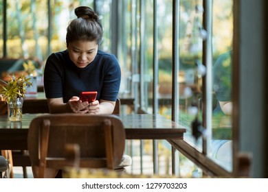 Beautiful Asian Woman Hand Using Smartphone Holidays Moment At Coffeeshop With Window Light And Garden