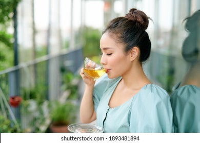 Beautiful Asian Woman Having Morning Tea At Balcony