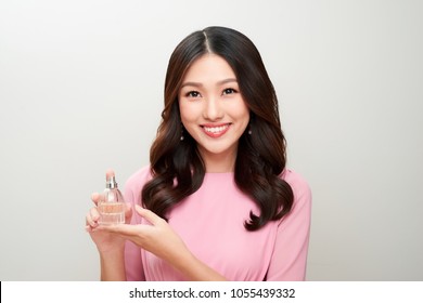 Beautiful Asian Woman Holding A Perfume Bottle And Applying It