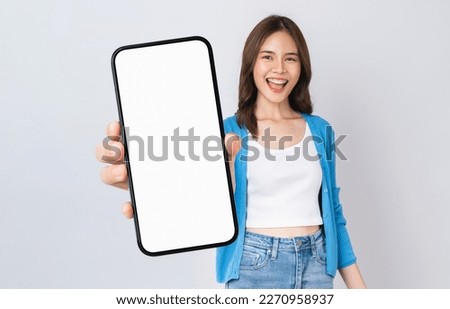 Beautiful Asian woman holding smartphone mockup of blank screen and smiling on white background.