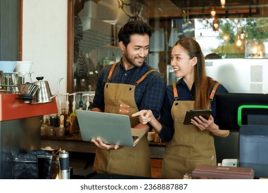 Beautiful Asian woman and Indian male small business owner looking at incoming orders in a cafe from a computer screen. and tablets sold through online applications to prepare food for customers	
 - Powered by Shutterstock